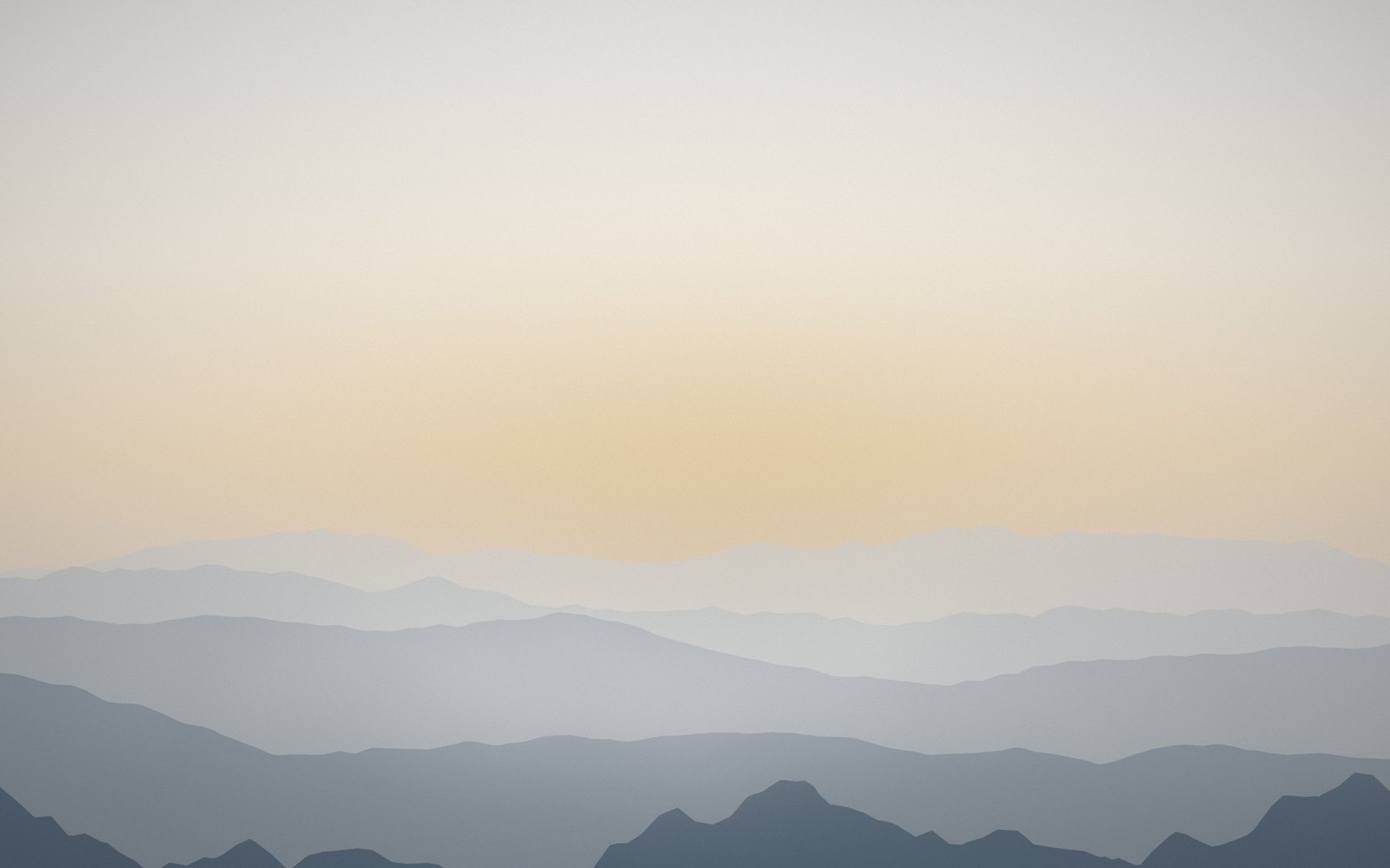 Layered ridgelines receding into dawn mist